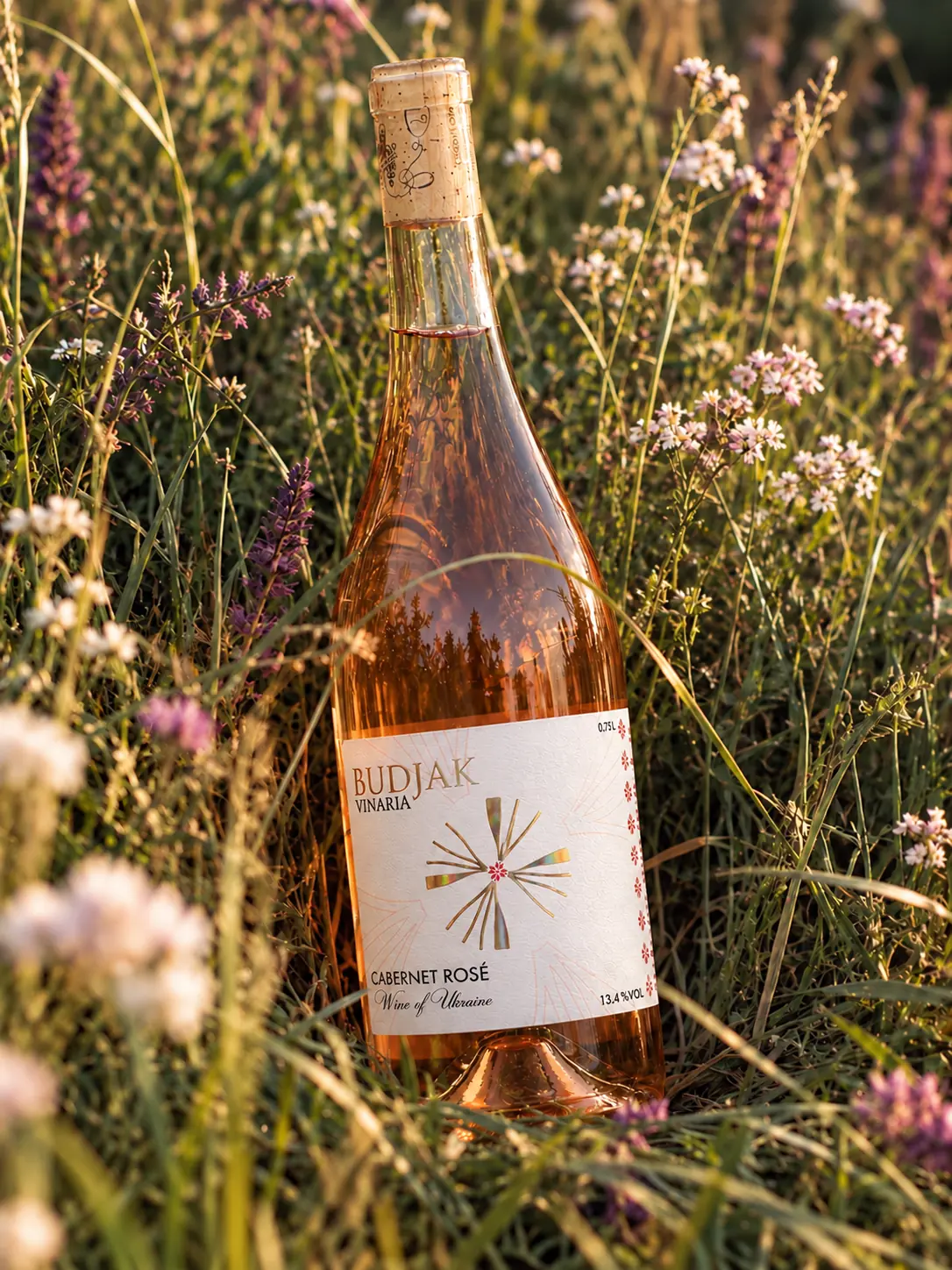 A bottle of Cabernet Rosé in a summer meadow of wild flowers